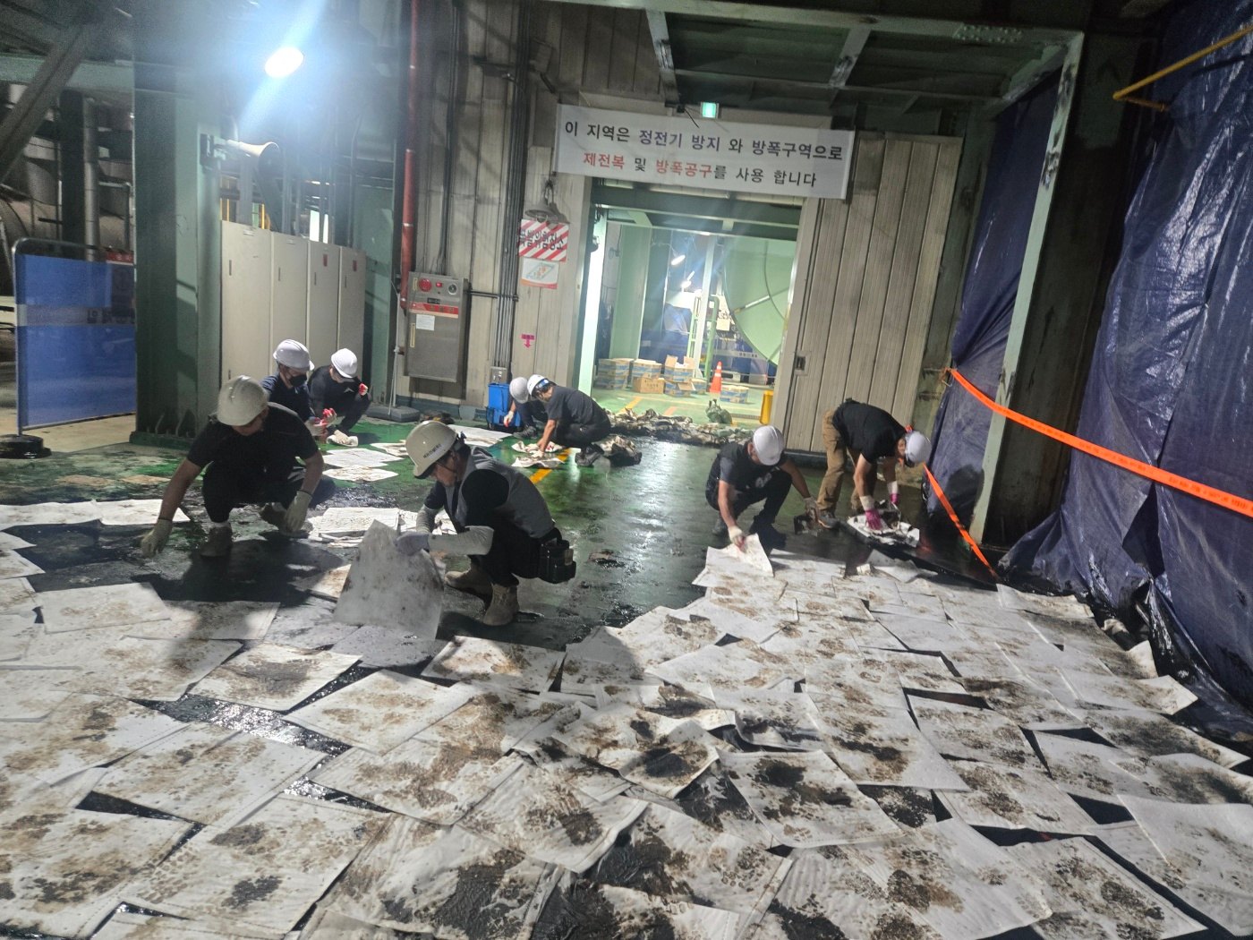 흡착포로 통로 바닥의 오일을 닦아내는 작업