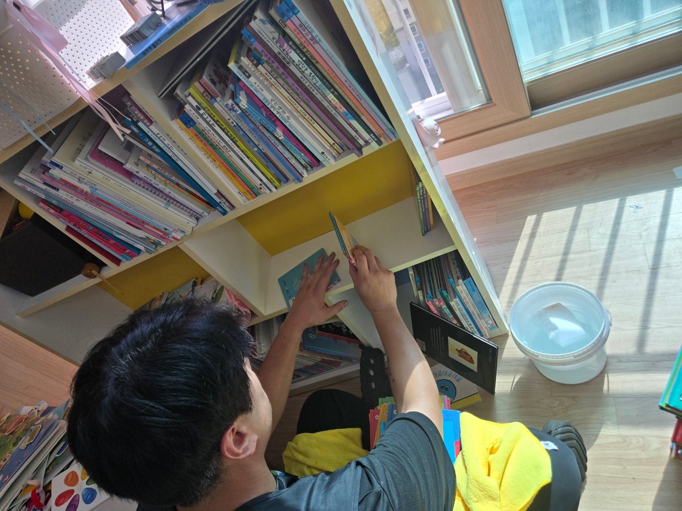 책장 주변 청소 중 책을 꺼내 다루는 과정